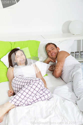 Image of Young couple having a lazy day in bed