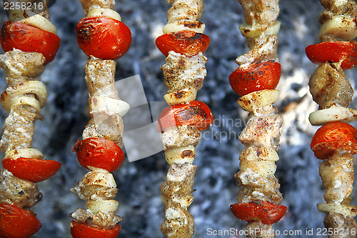 Image of meat with tomatoes on a grill