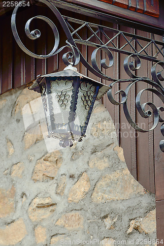 Image of An old street lamp on a stone wall