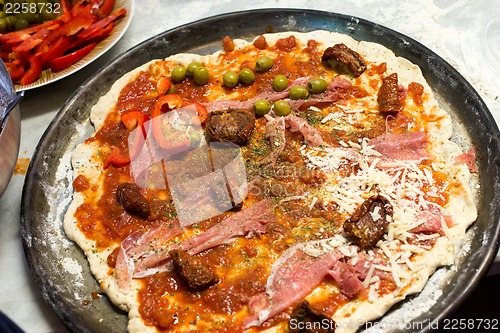 Image of raw pizza and ingredients