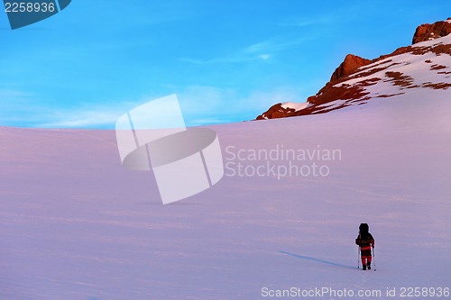 Image of Hiker in sunrise snow mountains