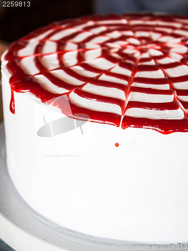 Image of Rasberry sauce topped white whipped cream cake 