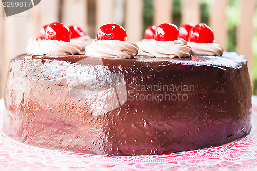 Image of Home made chocolate cake topped with cherry