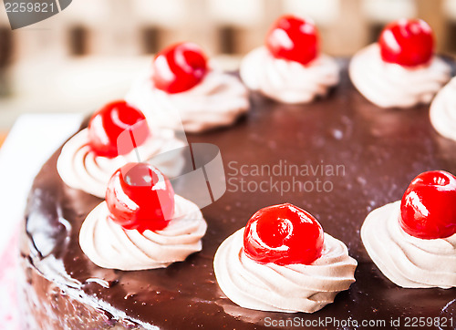 Image of Close up chocolate cake with cherry and whipped cream 