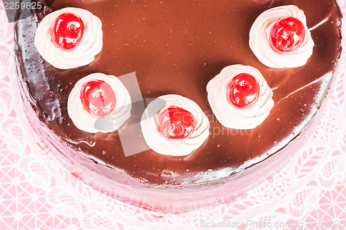 Image of Top view of chocolate cake with red cherry 