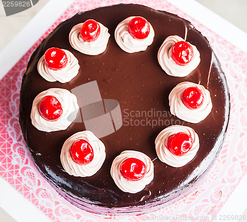 Image of Chocolate cake with whipped cream and cherry