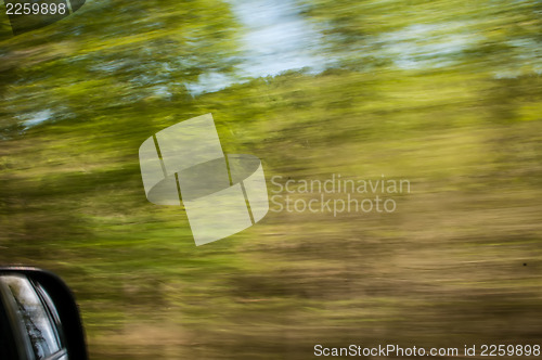 Image of blurred out country landscape while driving