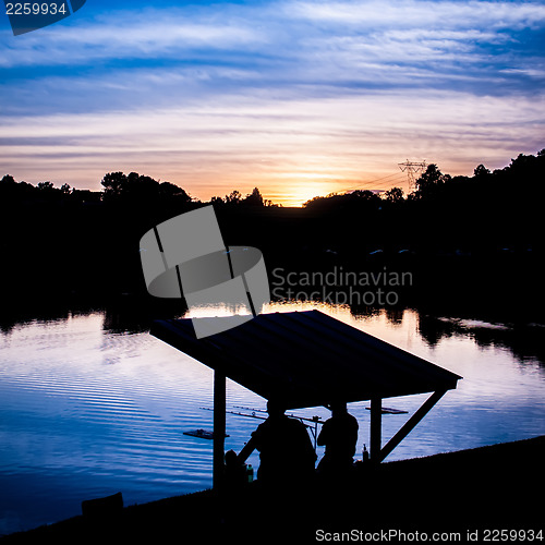 Image of fisherman fishing at  sunset
