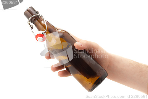 Image of Hand holds a bottle of beer. Isolated on white 