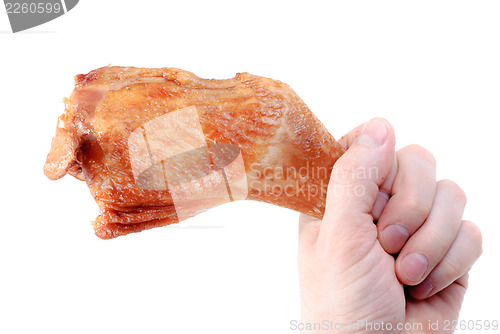 Image of Hand holds a hicken leg. Isolated on white  background