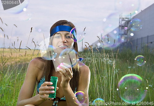 Image of woman blows soap bubbles