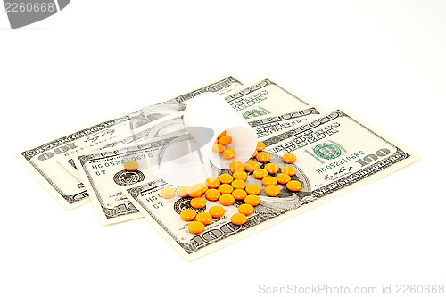 Image of orange pill at the money , isolated on white background 