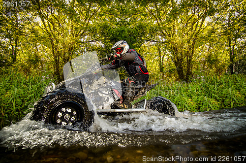 Image of Quad rider through water stream