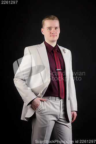 Image of young attractive man in a light suit and tie