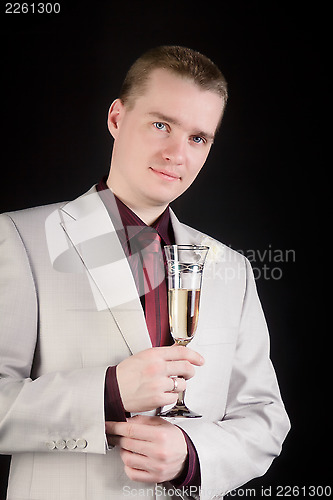 Image of young man in a suit with a glass of champagne
