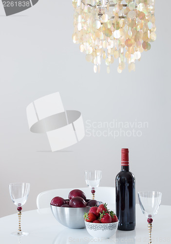 Image of Red wine with fruits on a table, and beautiful chandelier