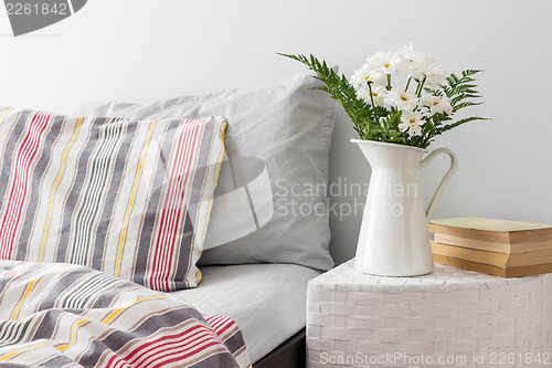 Image of White flowers and books on a bedside table