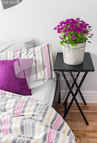 Image of Purple flowers in a bright bedroom