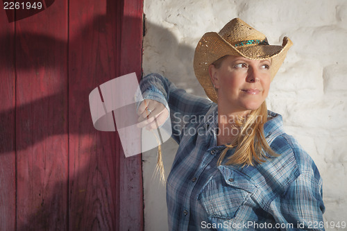 Image of Beautiful Cowgirl Against Old Wall and Red Door