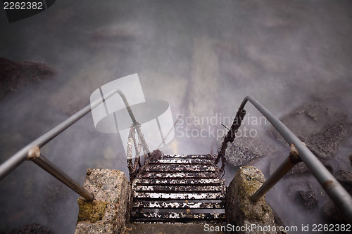 Image of Steel and stone old ladder to sea