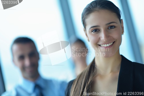 Image of business woman with her staff in background at office