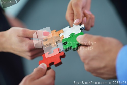 Image of Group of business people assembling jigsaw puzzle