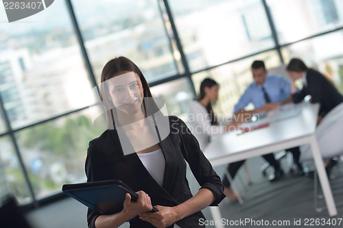 Image of business woman with her staff in background at office