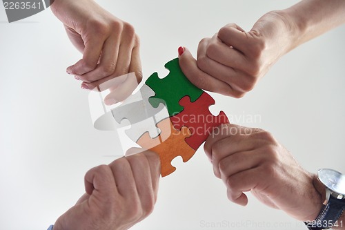 Image of Group of business people assembling jigsaw puzzle