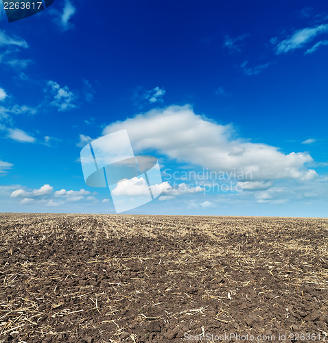 Image of black cultivated field and blue sky