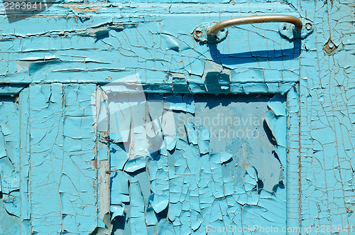 Image of part of cracked old painted blue door