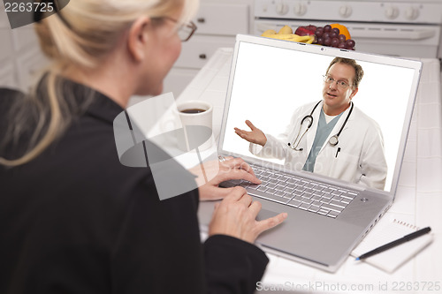 Image of Woman In Kitchen Using Laptop - Online with Nurse or Doctor