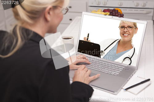 Image of Woman In Kitchen Using Laptop - Online with Nurse or Doctor