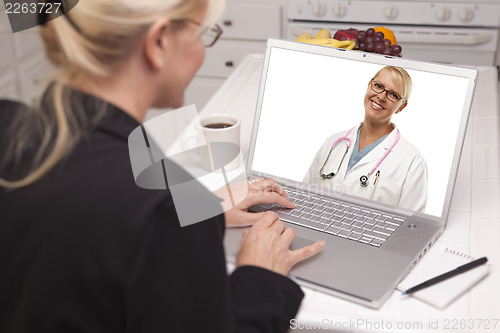 Image of Woman In Kitchen Using Laptop - Online with Nurse or Doctor