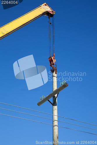 Image of Installation of wooden electric poles crane