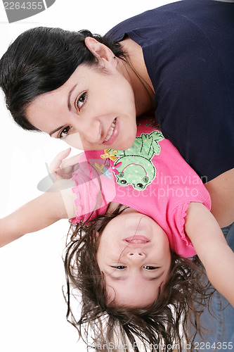 Image of Mother playing with her daughter and holding her upside down