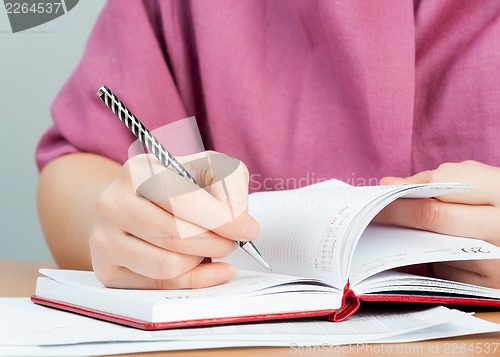 Image of Woman writing in organizer