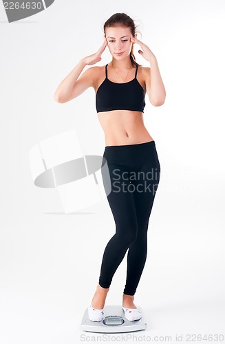 Image of happy young woman on weight scales