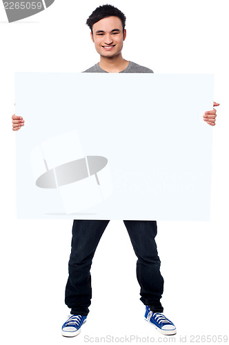Image of Handsome guy holding blank ad board