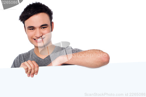 Image of Casual young guy holding blank whiteboard