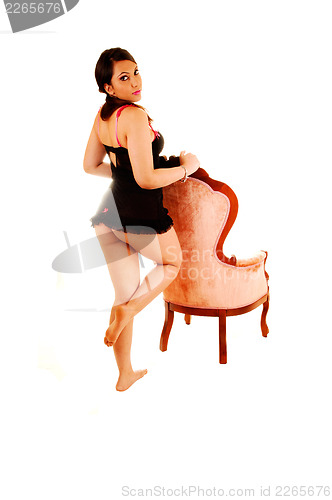 Image of Girl standing behind armchair.