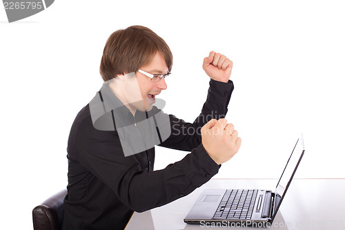 Image of Business man raises arms in front of his laptop