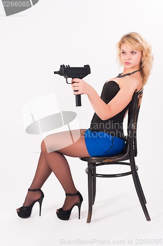 Image of Pretty girl with gun on chair