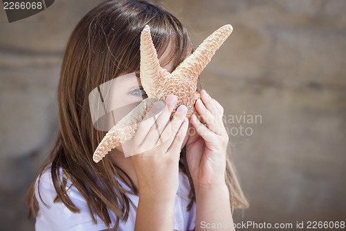 Image of Young Girl Playing with Starfish