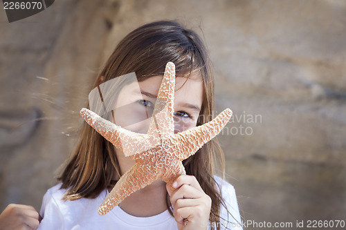 Image of Young Girl Playing with Starfish