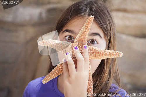 Image of Young Girl Playing with Starfish