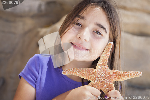 Image of Young Girl Playing with Starfish