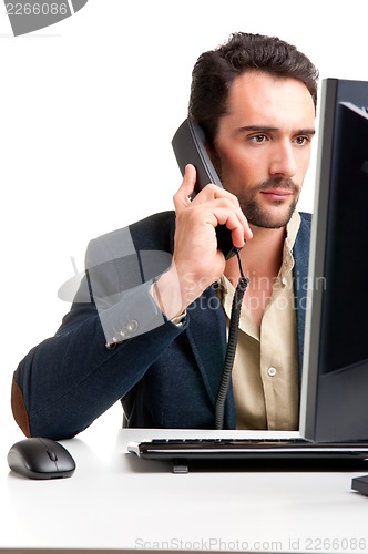 Image of Man Looking At A Computer Monitor, on the phone