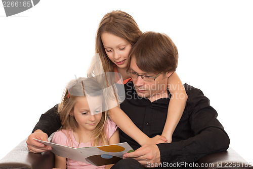 Image of Father read a book with his daughters