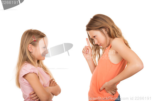 Image of Young girl pointing finger at her sister