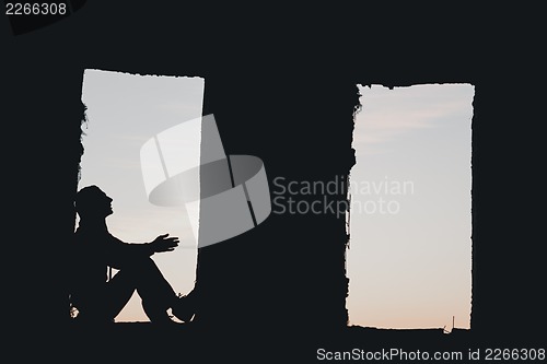 Image of Man's silhouette in the window above blue cloudy sky